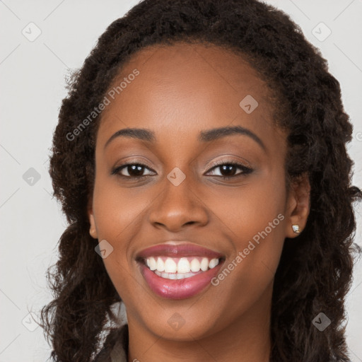 Joyful black young-adult female with long  brown hair and brown eyes