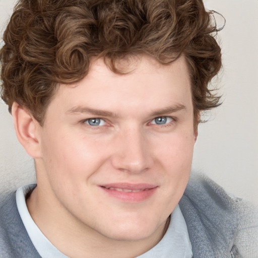 Joyful white young-adult male with short  brown hair and blue eyes