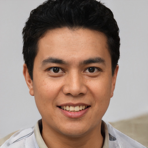 Joyful latino young-adult male with short  black hair and brown eyes