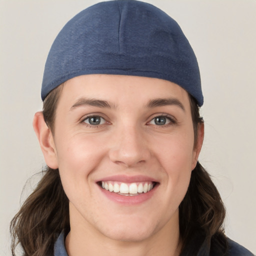 Joyful white young-adult female with medium  brown hair and grey eyes