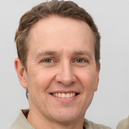 Joyful white adult male with short  brown hair and grey eyes