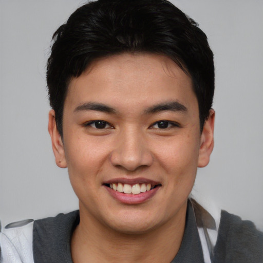 Joyful asian young-adult male with short  brown hair and brown eyes
