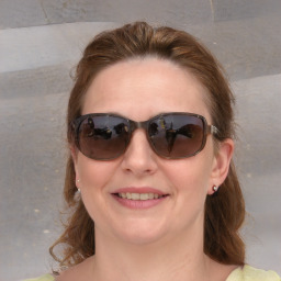 Joyful white young-adult female with medium  brown hair and blue eyes