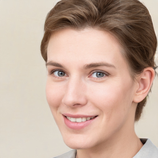 Joyful white young-adult female with short  brown hair and grey eyes