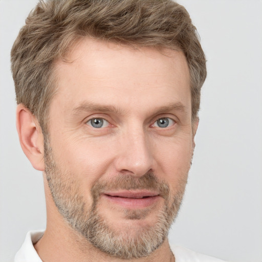 Joyful white adult male with short  brown hair and grey eyes