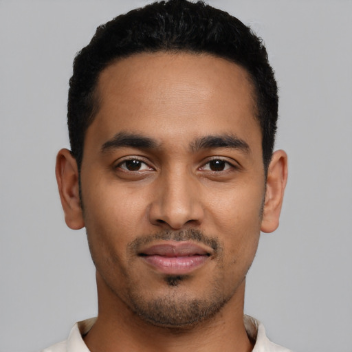 Joyful latino young-adult male with short  black hair and brown eyes