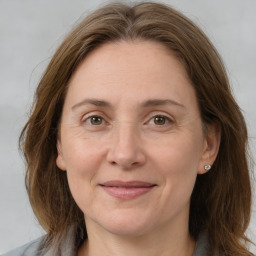 Joyful white adult female with long  brown hair and grey eyes