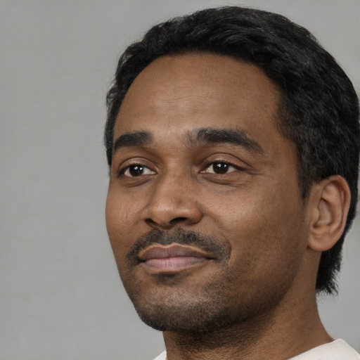Neutral black adult male with short  black hair and brown eyes