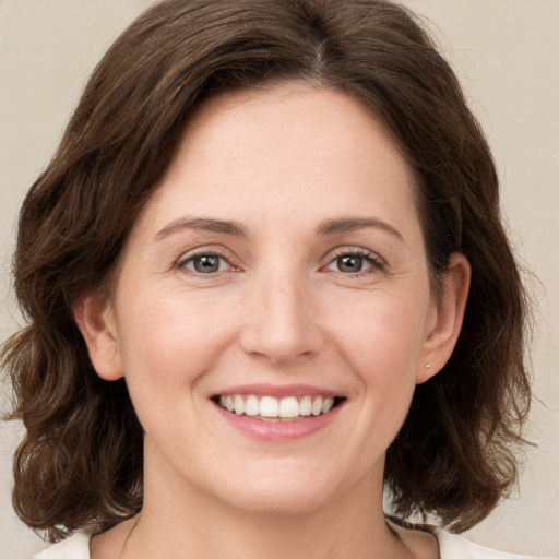 Joyful white young-adult female with medium  brown hair and green eyes