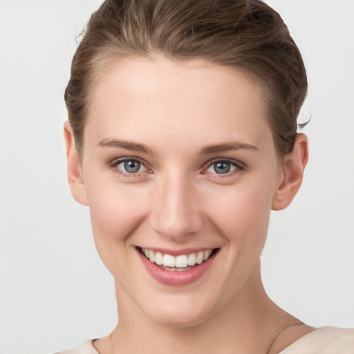 Joyful white young-adult female with short  brown hair and grey eyes