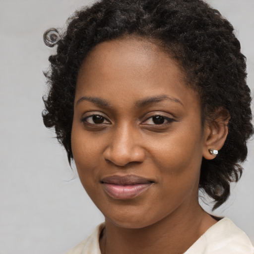 Joyful black young-adult female with medium  brown hair and brown eyes