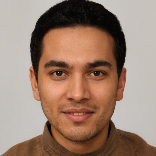 Joyful latino young-adult male with short  black hair and brown eyes
