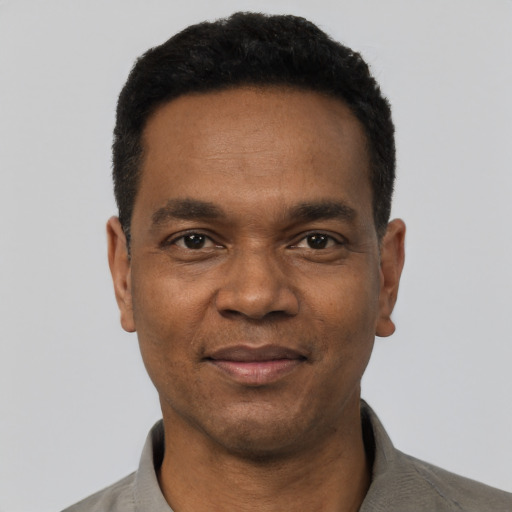 Joyful black adult male with short  black hair and brown eyes