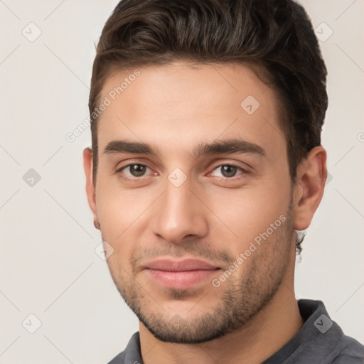 Joyful white young-adult male with short  brown hair and brown eyes