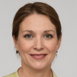 Joyful white adult female with medium  brown hair and grey eyes