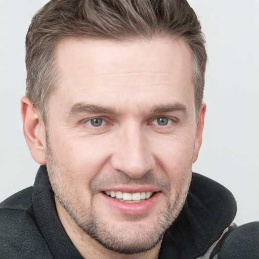 Joyful white adult male with short  brown hair and grey eyes