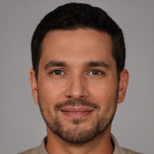 Joyful white young-adult male with short  black hair and brown eyes