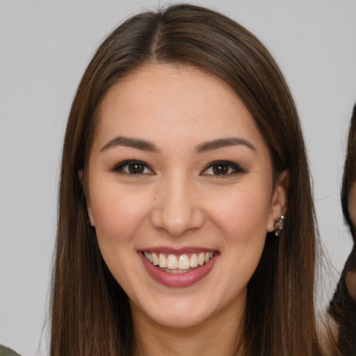 Joyful white young-adult female with long  brown hair and brown eyes