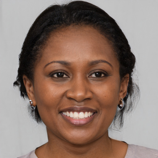 Joyful black young-adult female with medium  black hair and brown eyes