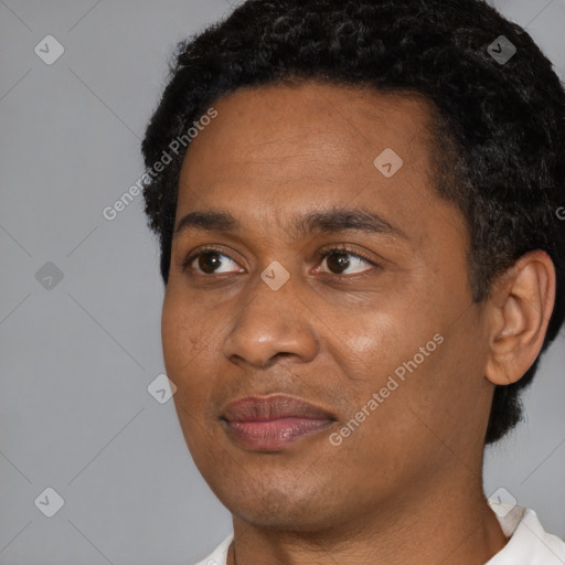 Joyful black young-adult male with short  black hair and brown eyes