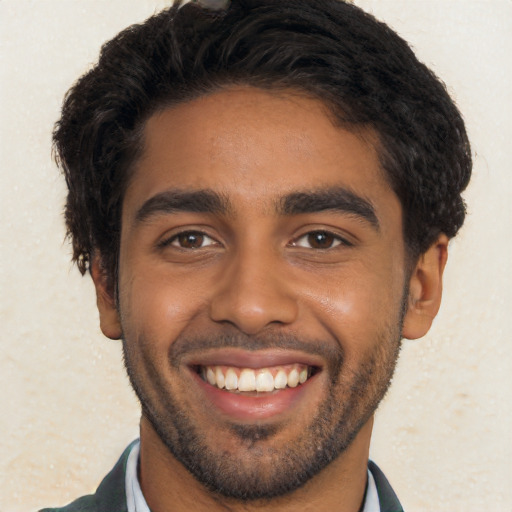 Joyful black young-adult male with short  black hair and brown eyes