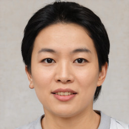 Joyful asian young-adult female with short  black hair and brown eyes