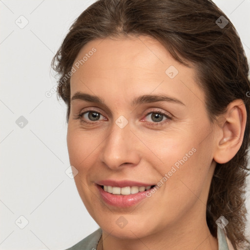 Joyful white young-adult female with medium  brown hair and grey eyes