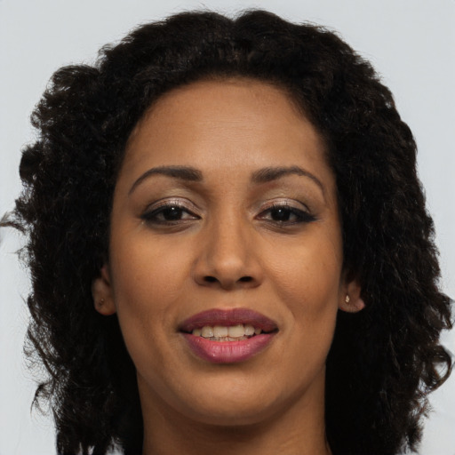 Joyful latino adult female with long  brown hair and brown eyes