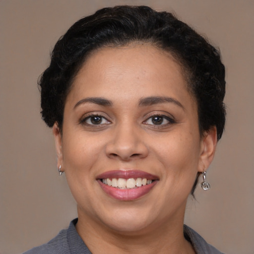 Joyful latino adult female with short  brown hair and brown eyes