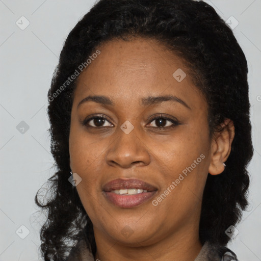 Joyful black young-adult female with long  brown hair and brown eyes