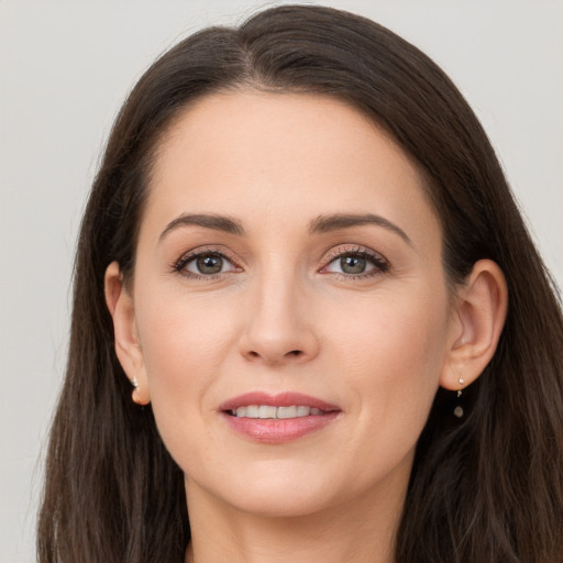 Joyful white young-adult female with long  brown hair and grey eyes