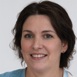 Joyful white adult female with medium  brown hair and brown eyes