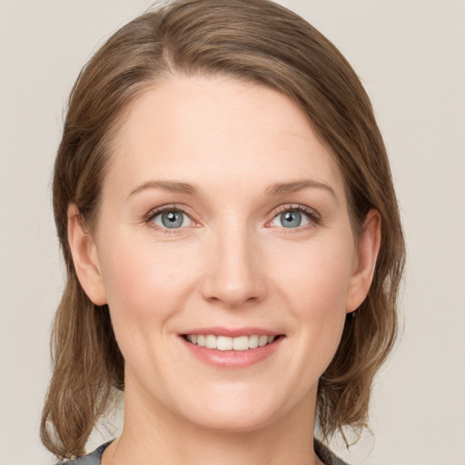 Joyful white young-adult female with medium  brown hair and green eyes