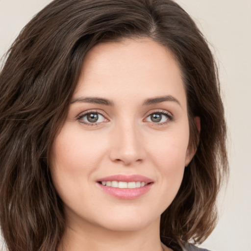 Joyful white young-adult female with long  brown hair and green eyes