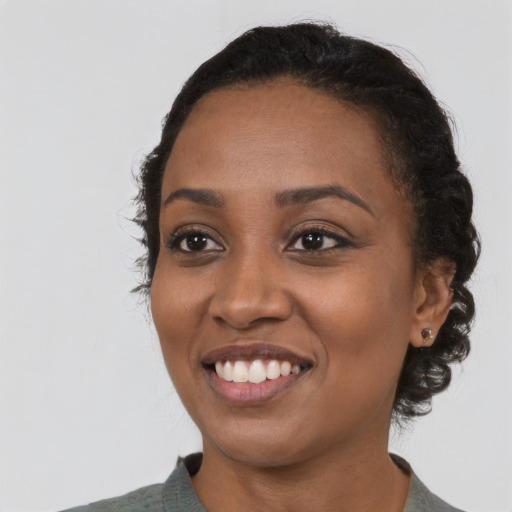 Joyful black young-adult female with medium  black hair and brown eyes