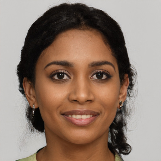 Joyful black young-adult female with medium  black hair and brown eyes