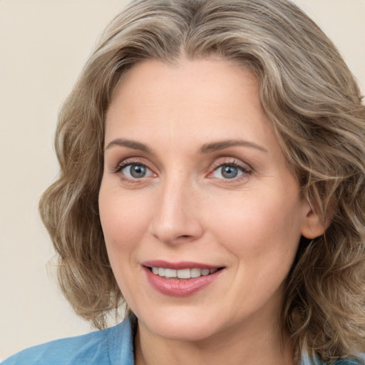 Joyful white adult female with medium  brown hair and green eyes