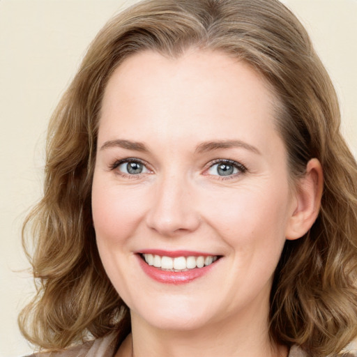 Joyful white young-adult female with long  brown hair and blue eyes