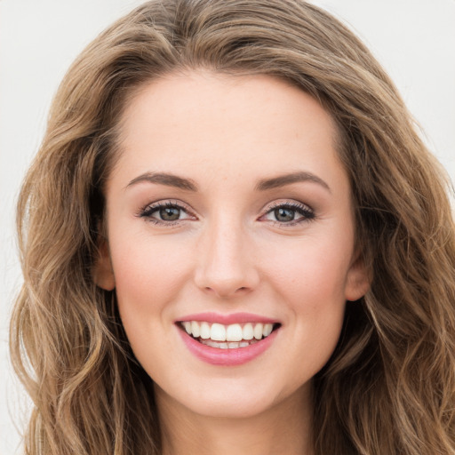 Joyful white young-adult female with long  brown hair and green eyes