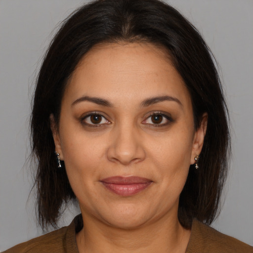 Joyful latino adult female with medium  brown hair and brown eyes