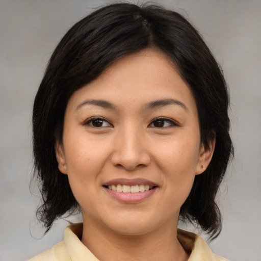 Joyful asian young-adult female with medium  brown hair and brown eyes
