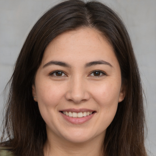 Joyful white young-adult female with long  brown hair and brown eyes