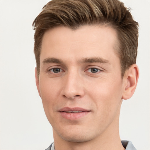 Joyful white young-adult male with short  brown hair and grey eyes