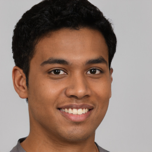 Joyful latino young-adult male with short  brown hair and brown eyes