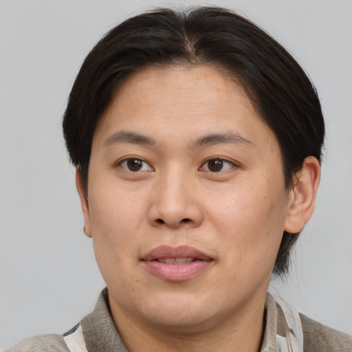 Joyful asian adult male with short  brown hair and brown eyes