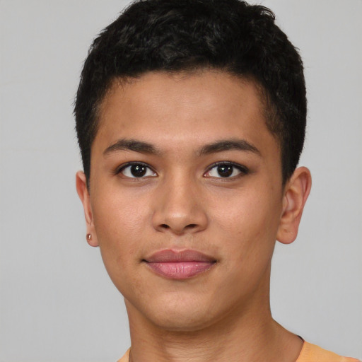 Joyful latino young-adult male with short  brown hair and brown eyes