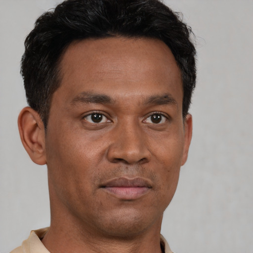 Joyful latino adult male with short  brown hair and brown eyes