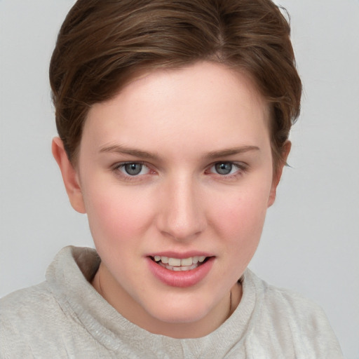 Joyful white young-adult female with short  brown hair and blue eyes