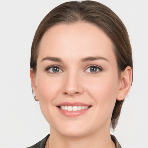 Joyful white young-adult female with medium  brown hair and grey eyes