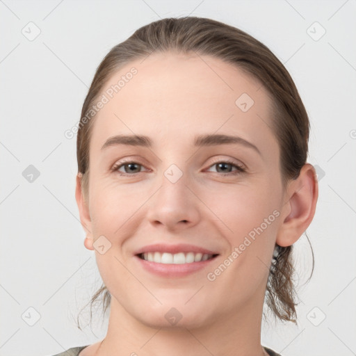 Joyful white young-adult female with medium  brown hair and grey eyes